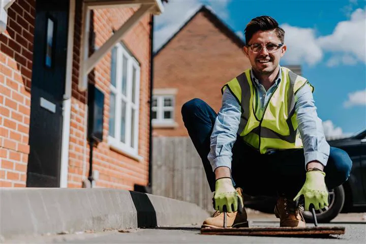 Simon Crowther lifting an inspection cover on a residential street