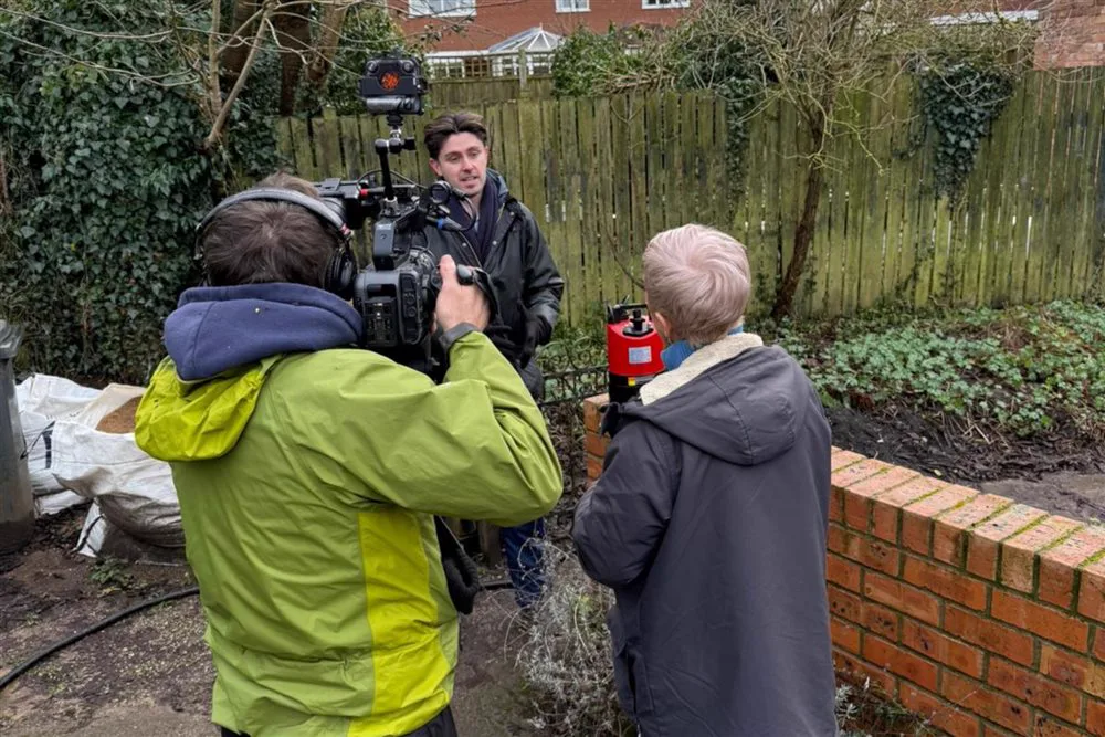 Simon Crowther being filmed by a BBC crew in a flood-hit garden in Woodborough
